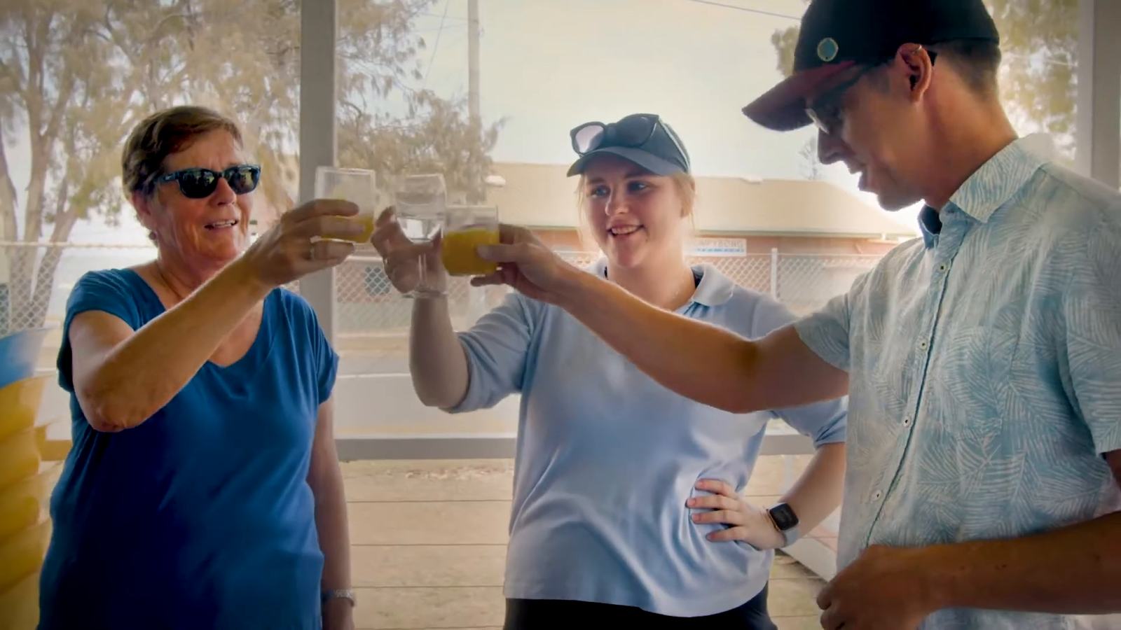 Players raising their glasses together on a clubhouse verandah