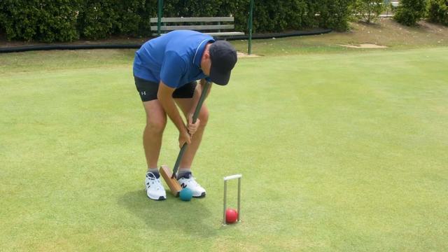 A player in blue lining up a ball at a hoop